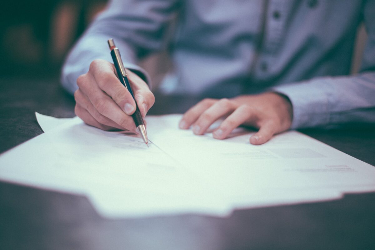 A man signing a contract to get travel insurance repatriation of mortal remains